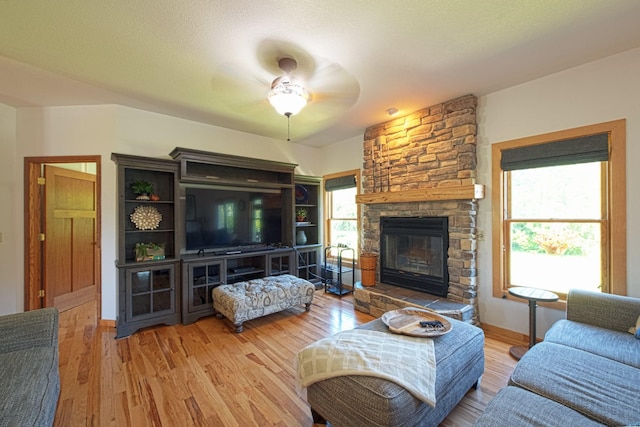 10199 330th St W, Northfield, MN 55057 - living room with ceiling fan, plenty of natural light, wood finished floors, and a stone fireplace