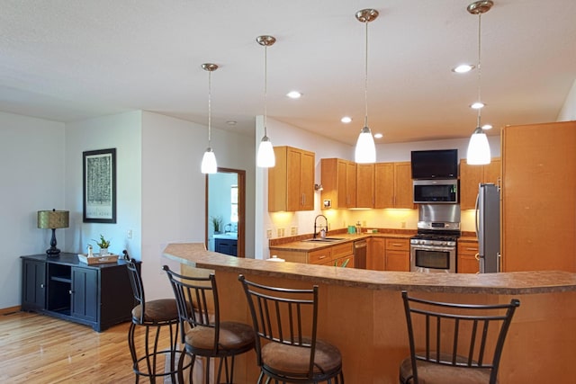 10199 330th St W, Northfield, MN 55057 - kitchen featuring stainless steel appliances, light wood-type flooring, a breakfast bar, hanging light fixtures, and recessed lighting