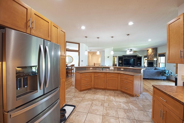 10199 330th St W, Northfield, MN 55057 - kitchen with stainless steel fridge, open floor plan, a fireplace, dark countertops, and hanging light fixtures