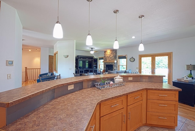 10199 330th St W, Northfield, MN 55057 - kitchen with open floor plan, a stone fireplace, and hanging light fixtures