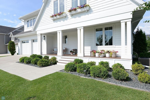 2630 2nd St E, Fargo, ND 58078 - view of front facade featuring covered porch, driveway, an attached garage, and a front lawn