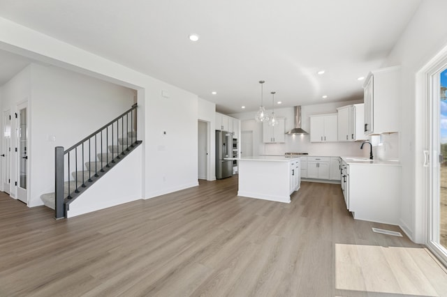 9863 49th St NE, Saint Michael, MN 55376 - kitchen with a kitchen island, light wood-style floors, high end fridge, wall chimney range hood, and recessed lighting