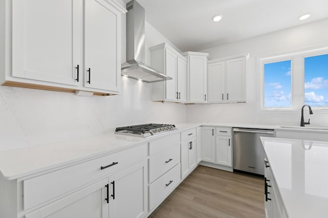 9863 49th St NE, Saint Michael, MN 55376 - kitchen featuring wall chimney exhaust hood, appliances with stainless steel finishes, white cabinets, light wood finished floors, and recessed lighting