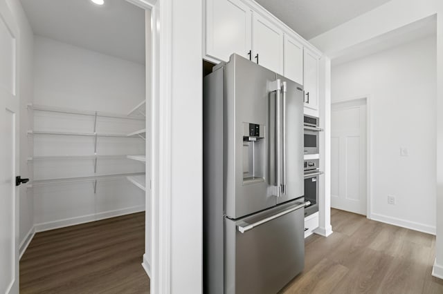 9863 49th St NE, Saint Michael, MN 55376 - kitchen with stainless steel appliances, wood finished floors, and white cabinetry