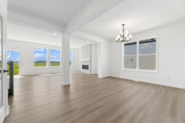 9863 49th St NE, Saint Michael, MN 55376 - unfurnished living room with a chandelier, wood finished floors, a stone fireplace, recessed lighting, and beamed ceiling