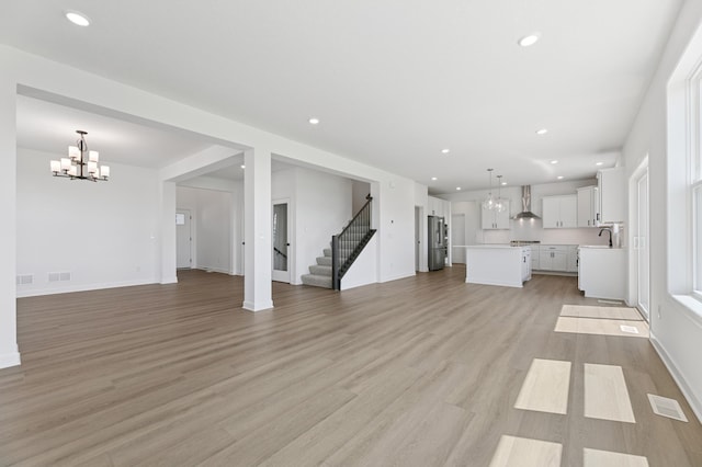 9863 49th St NE, Saint Michael, MN 55376 - unfurnished living room featuring a chandelier, stairway, light wood finished floors, and recessed lighting