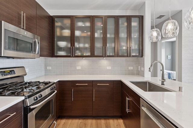 929 Portland Ave Unit 2510, Minneapolis, MN 55404 - kitchen featuring stainless steel appliances, dark brown cabinets, modern cabinets, and tasteful backsplash