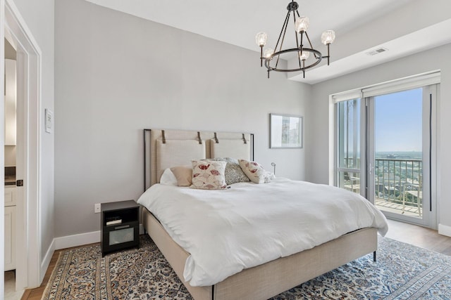 929 Portland Ave Unit 2510, Minneapolis, MN 55404 - bedroom featuring access to exterior, a chandelier, and light wood-style floors