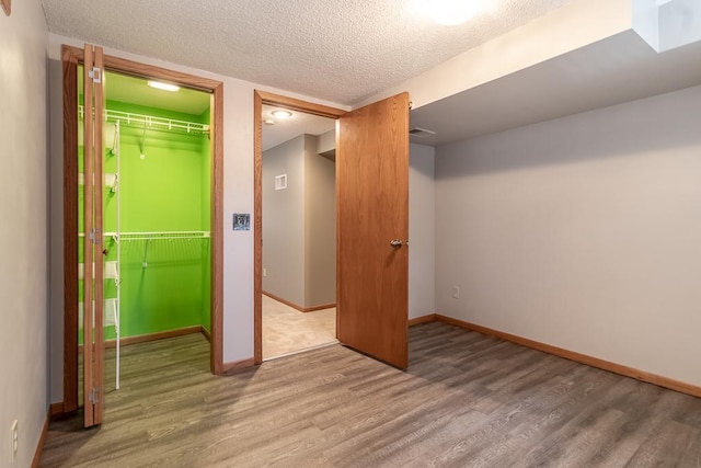 315 Pierce Ave, North Mankato, MN 56003 - unfurnished bedroom featuring wood finished floors, a textured ceiling, and a closet