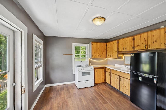 1818 1st St N, Stillwater, MN 55082 - kitchen featuring freestanding refrigerator, white range with gas stovetop, dark wood finished floors, and light countertops