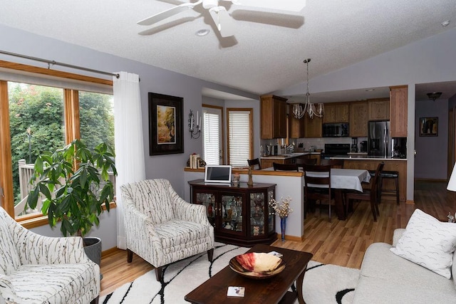 2518 Parkhill Ln SW, Rochester, MN 55902 - living area featuring lofted ceiling, ceiling fan, light wood-style flooring, and a chandelier