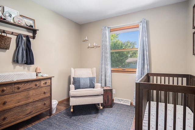 501 Central Ln, Luverne, MN 56156 - bedroom featuring a crib and wood finished floors