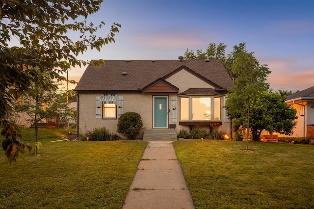 579 36th Ave NE, Minneapolis, MN 55418 - view of front facade with roof with shingles, a lawn, and stucco siding