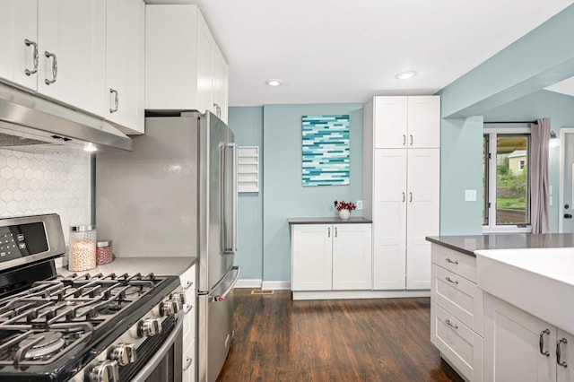 579 36th Ave NE, Minneapolis, MN 55418 - kitchen featuring stainless steel gas stove, under cabinet range hood, dark wood finished floors, white cabinetry, and backsplash