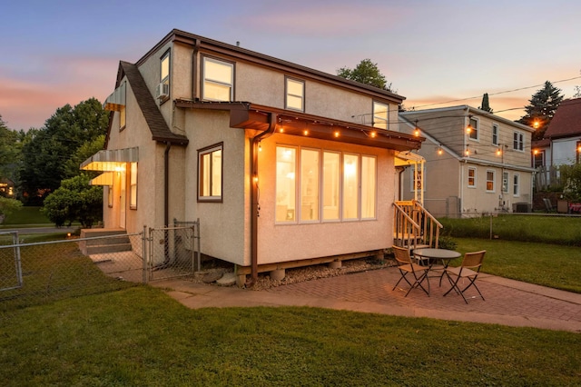 579 36th Ave NE, Minneapolis, MN 55418 - back of property at dusk featuring stucco siding, a patio area, and cooling unit