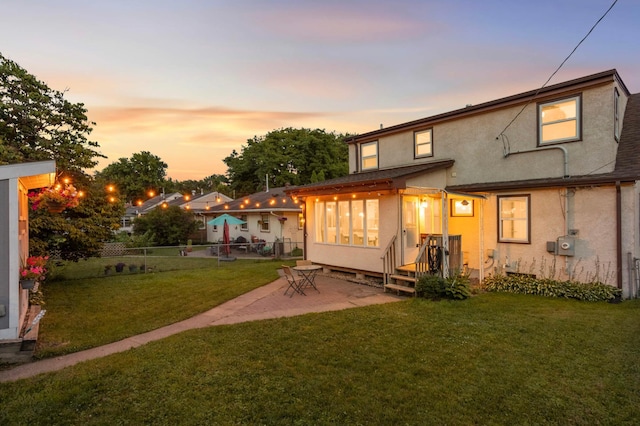 579 36th Ave NE, Minneapolis, MN 55418 - back of house at dusk with stucco siding and a patio area