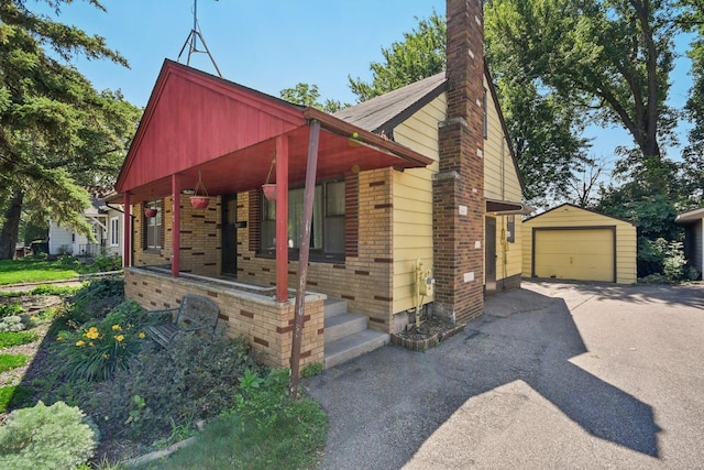 272 Butler Ave E, West Saint Paul, MN 55118 - view of front of property with driveway, an outdoor structure, a garage, a chimney, and brick siding