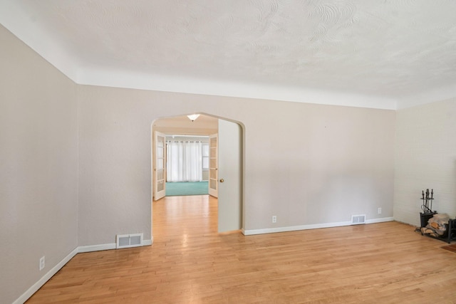 272 Butler Ave E, West Saint Paul, MN 55118 - spare room featuring arched walkways and light wood-style flooring