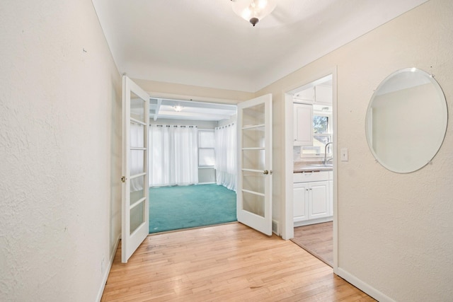 272 Butler Ave E, West Saint Paul, MN 55118 - hallway with french doors, light wood finished floors, and a textured wall