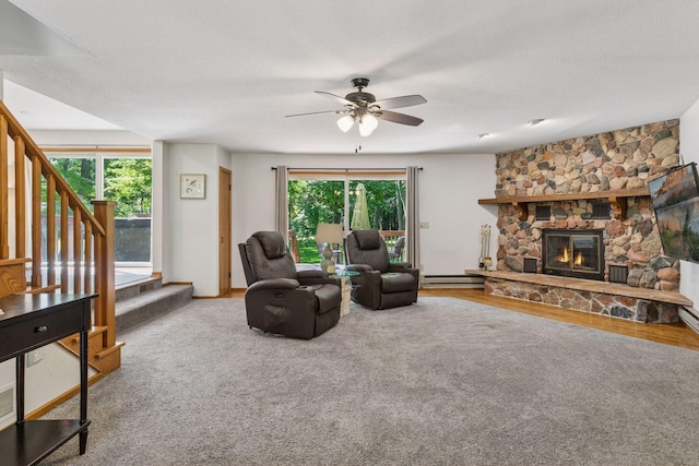 16059 Kettle River Blvd NE, Columbus, MN 55025 - living room featuring ceiling fan, a fireplace, stairs, and a baseboard heating unit