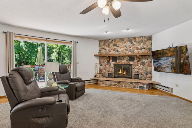 16059 Kettle River Blvd NE, Columbus, MN 55025 - living area with ceiling fan, a stone fireplace, wood finished floors, baseboard heating, and a textured ceiling
