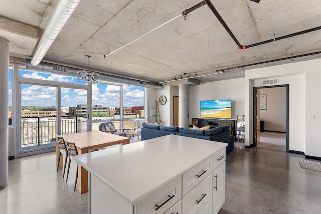 730 4th St Unit 601, Minneapolis, MN 55401 - kitchen featuring white cabinets, plenty of natural light, a kitchen island, and concrete flooring
