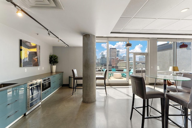 730 4th St Unit 601, Minneapolis, MN 55401 - dining space featuring a skyline view, rail lighting, beverage cooler, floor to ceiling windows, and finished concrete flooring