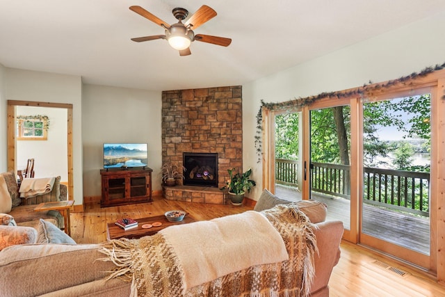31338 Oasis Rd, Center City, MN 55012 - living area with healthy amount of natural light, ceiling fan, light wood-style flooring, and a stone fireplace