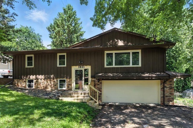1821 Wilson Ave, Saint Paul, MN 55106 - bi-level home featuring a garage, asphalt driveway, and a front yard