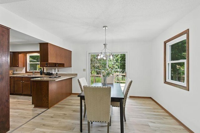 1821 Wilson Ave, Saint Paul, MN 55106 - dining room with light wood finished floors, plenty of natural light, and a chandelier