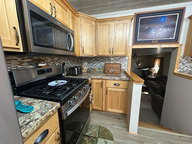 406 State 6 S, Remer, MN 56672 - kitchen with stainless steel appliances, light wood finished floors, and tasteful backsplash