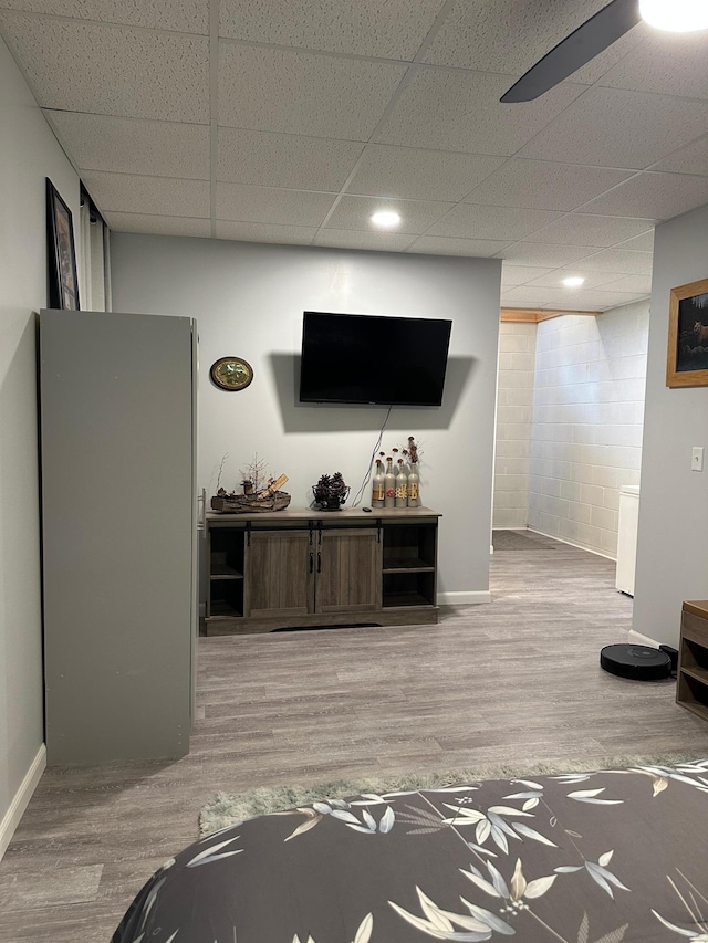 406 State 6 S, Remer, MN 56672 - living area featuring wood finished floors, a paneled ceiling, and concrete block wall