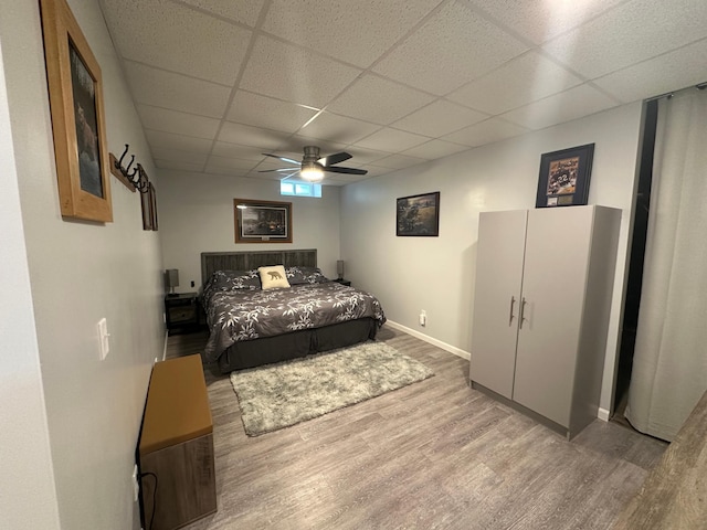 406 State 6 S, Remer, MN 56672 - bedroom featuring wood finished floors, a paneled ceiling, and a ceiling fan