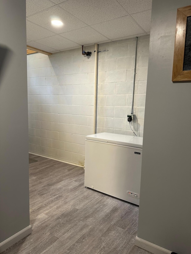 406 State 6 S, Remer, MN 56672 - finished basement with fridge, wood finished floors, and concrete block wall