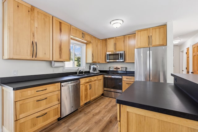3205 Adair Ave NE, Buffalo, MN 55313 - kitchen featuring stainless steel appliances, light wood-type flooring, dark countertops, and light brown cabinetry