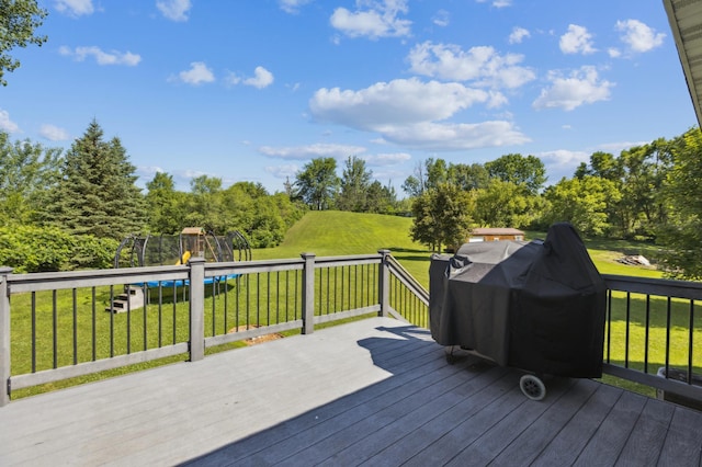 3205 Adair Ave NE, Buffalo, MN 55313 - wooden deck featuring a trampoline, a yard, a grill, and a playground