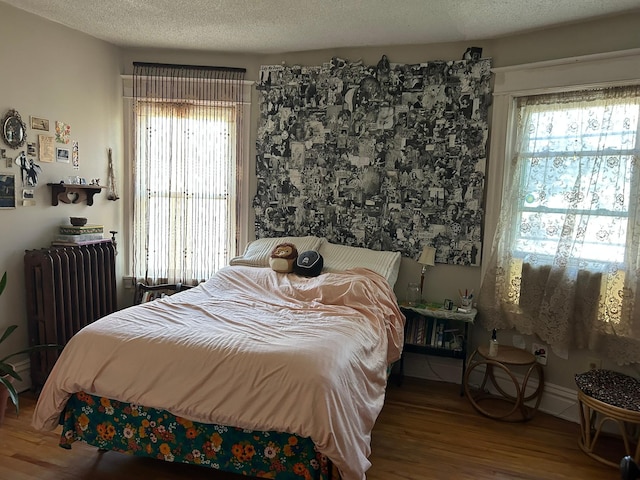 1636 Minnehaha Ave W, Saint Paul, MN 55104 - bedroom featuring radiator, wood finished floors, and a textured ceiling