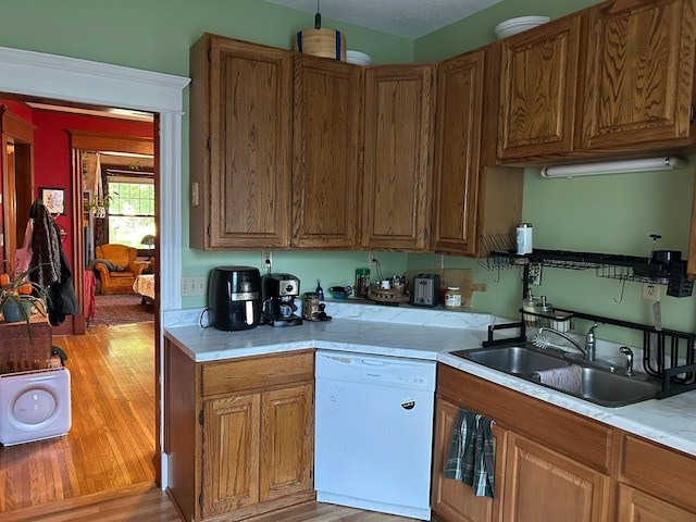 1636 Minnehaha Ave W, Saint Paul, MN 55104 - kitchen featuring white dishwasher, light countertops, light wood finished floors, and brown cabinetry