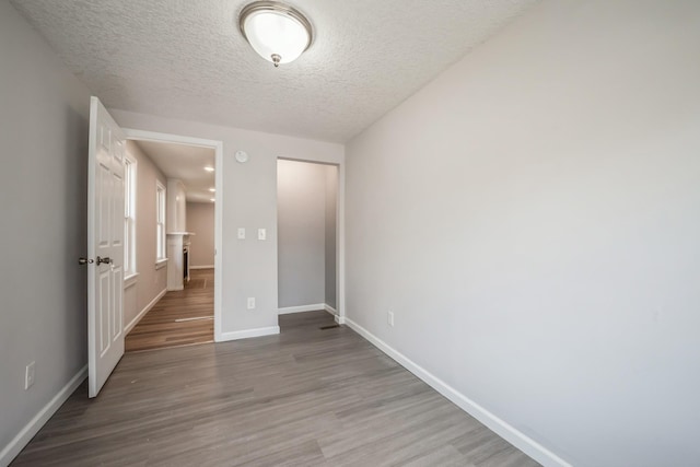 3624 15th Ave S, Minneapolis, MN 55407 - unfurnished bedroom with wood finished floors, a closet, and a textured ceiling