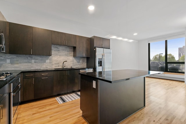 1240 2nd St Unit 225, Minneapolis, MN 55415 - kitchen featuring stainless steel appliances, light wood-style floors, decorative backsplash, and recessed lighting