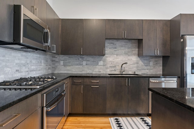 1240 2nd St Unit 225, Minneapolis, MN 55415 - kitchen featuring stainless steel appliances, dark stone countertops, dark brown cabinets, and backsplash