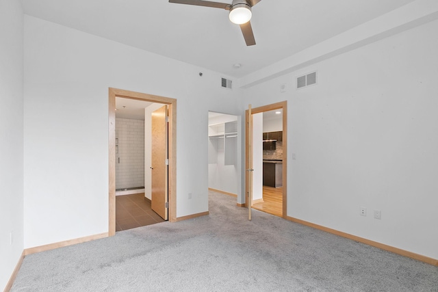 1240 2nd St Unit 225, Minneapolis, MN 55415 - unfurnished bedroom featuring carpet, a walk in closet, ensuite bathroom, and ceiling fan