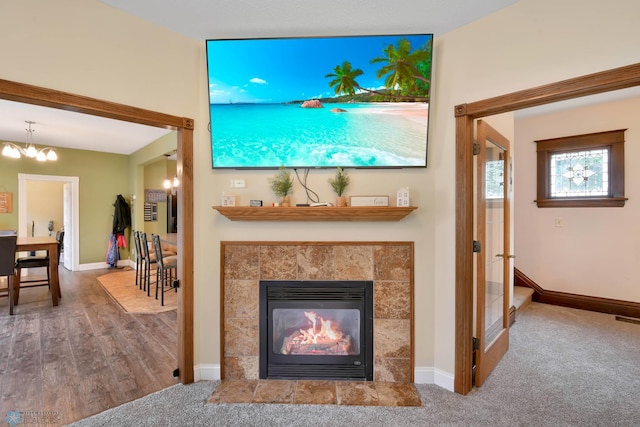 51 6th Ave N, Fargo, ND 58102 - carpeted living area with a chandelier, a fireplace, and wood finished floors