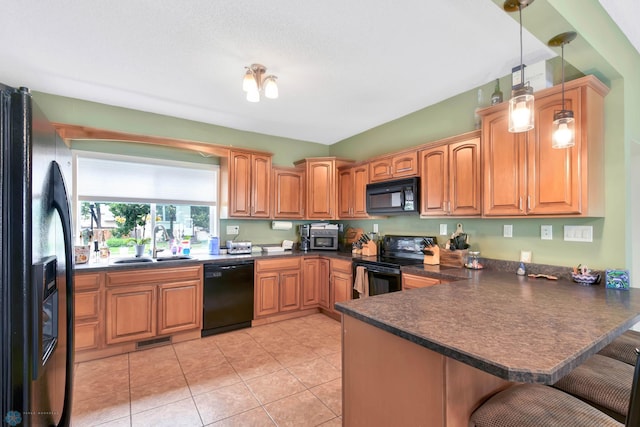 51 6th Ave N, Fargo, ND 58102 - kitchen featuring black appliances, dark countertops, a peninsula, and a breakfast bar area