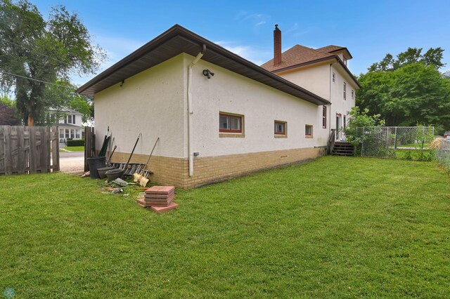 51 6th Ave N, Fargo, ND 58102 - view of property exterior featuring stucco siding and a chimney