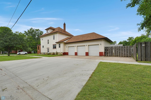 51 6th Ave N, Fargo, ND 58102 - view of front facade featuring stucco siding, an attached garage, driveway, and a chimney
