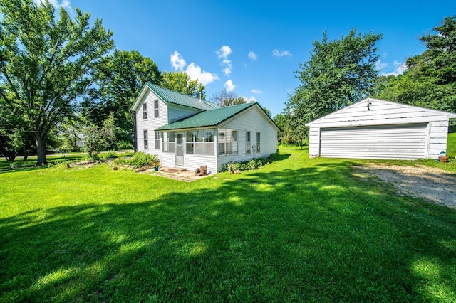 415 Minnesota Ave S, Oronoco, MN 55960 - rear view of house with a garage, an outbuilding, a sunroom, a lawn, and a metal roof