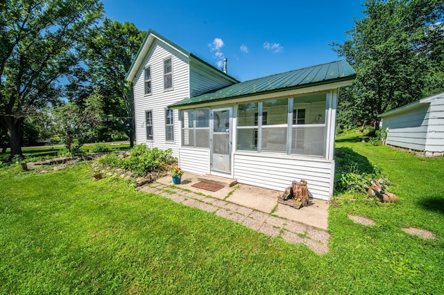 415 Minnesota Ave S, Oronoco, MN 55960 - back of property with a sunroom, a lawn, and a metal roof