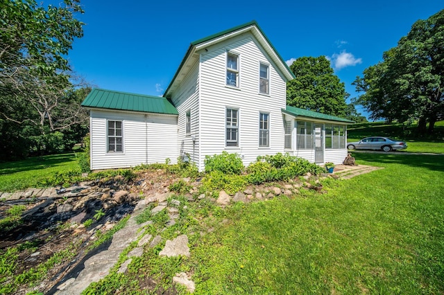 415 Minnesota Ave S, Oronoco, MN 55960 - view of property exterior featuring a sunroom, a yard, and a metal roof