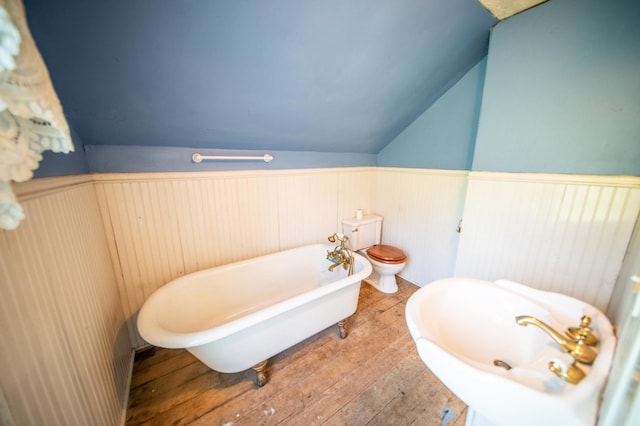 415 Minnesota Ave S, Oronoco, MN 55960 - bathroom with wainscoting, a soaking tub, lofted ceiling, and hardwood / wood-style flooring
